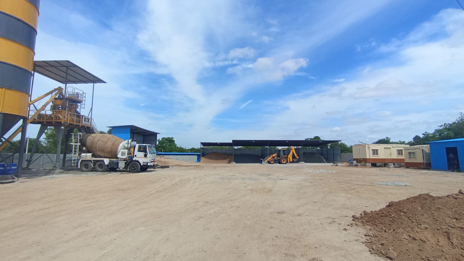 Batching plant yard with silos, transit mixer, aggregate storage, and site offices